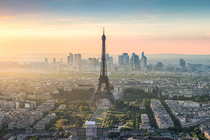 Zinc rooftops and the Eiffel Tower under a late Paris sky